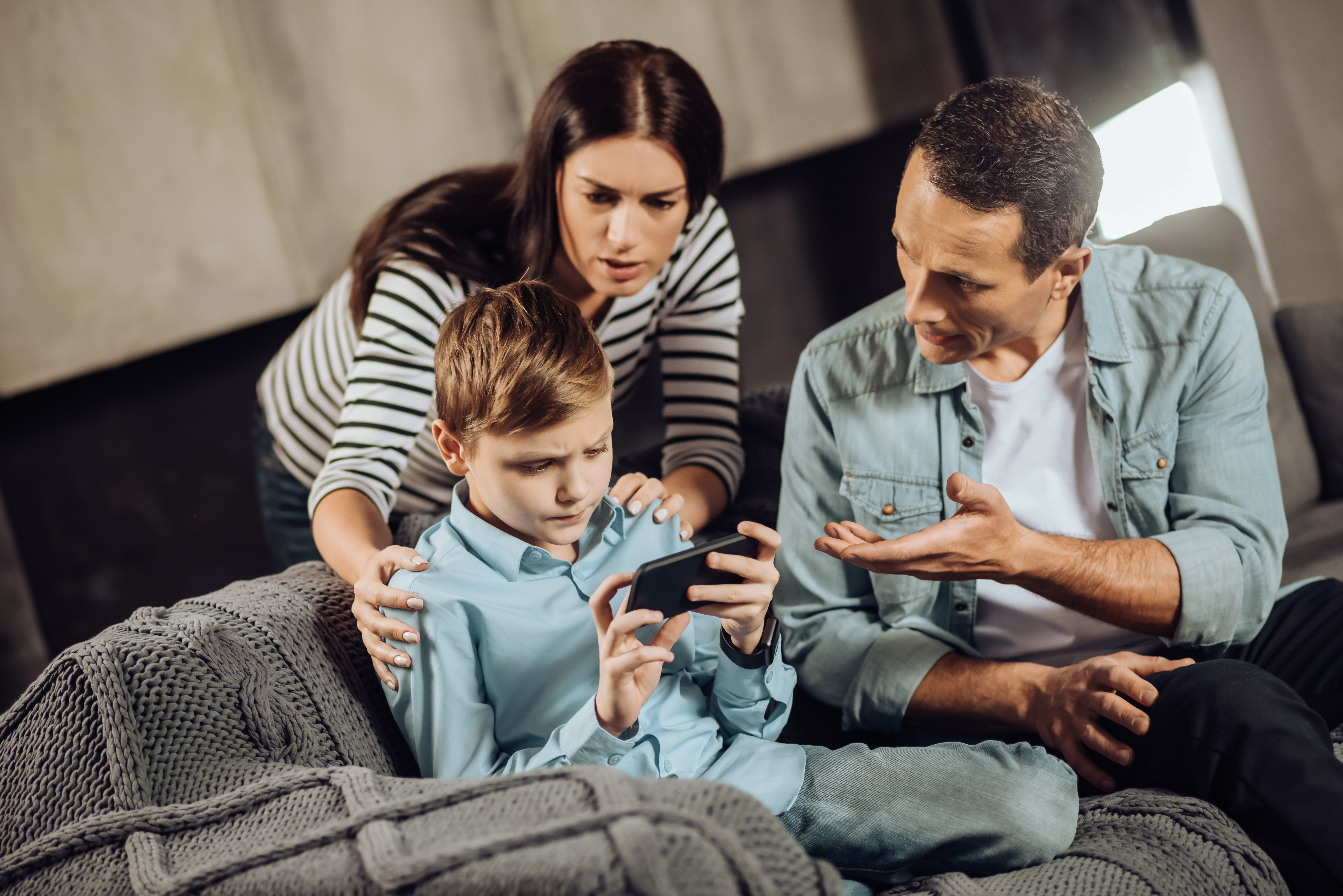 Loving parents convincing son to put down the phone